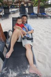 Darwin held by daddy sitting on beach chair at Gran Bahia Principe Sian Kaan private beach.jpg