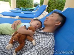 Darwin falls asleep on daddy's chest while holding monkey at GR Solaris pool chair.jpg