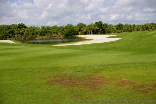 Small lagoon surrounded by sand at the Playa Mujeres golf course.jpg