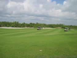 Golfers and golf carts on a fairway at Playa Mujeres golf course.jpg