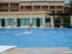 Trainer rides a dolphin at Dolphinaris at Gran Bahia Principe Resort.jpg