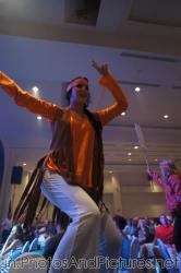 Woman performer dances on table in a 70s costume at GR Solaris.jpg