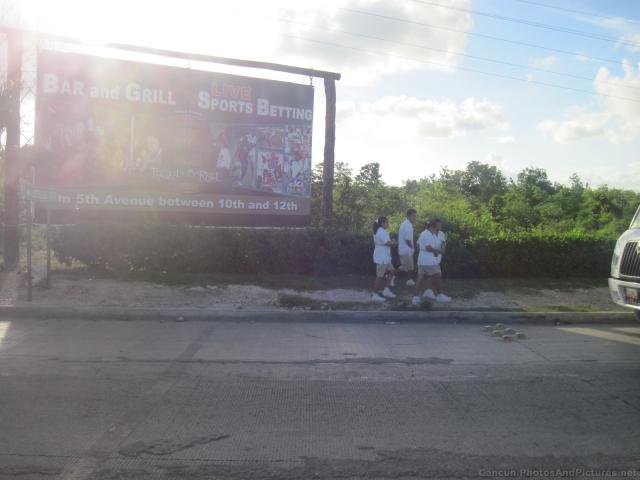 Playa del Carmen sign and people walking.jpg